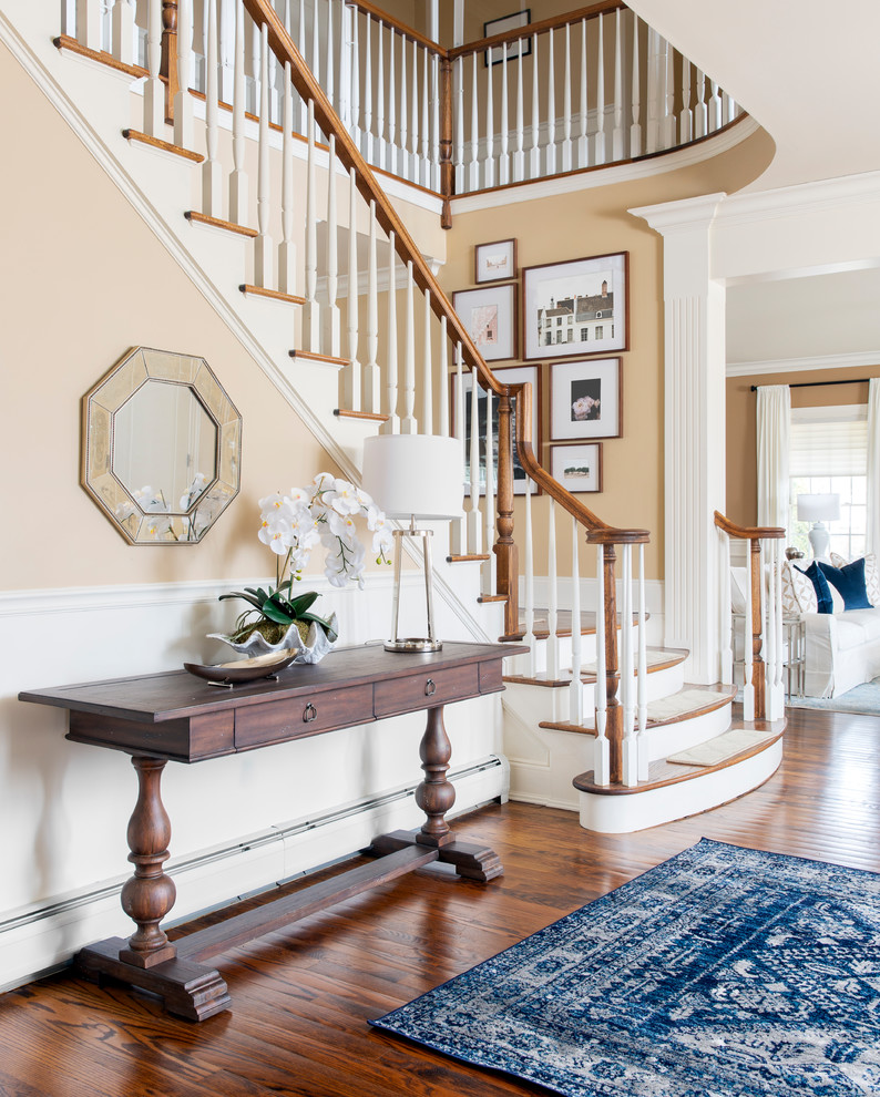 Photo of a mid-sized traditional foyer in New York with beige walls, brown floor and dark hardwood floors.