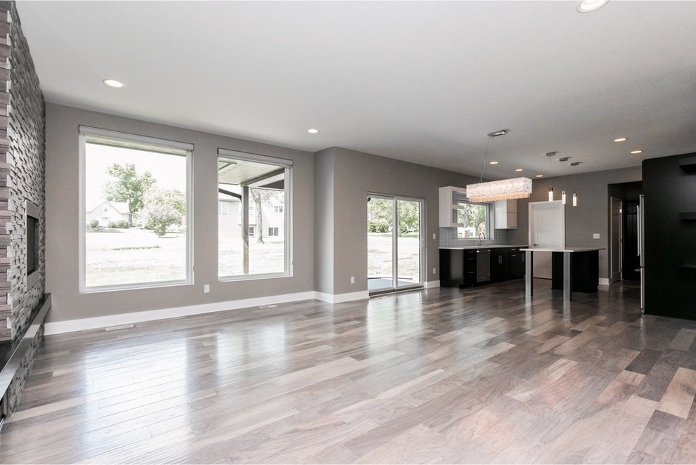 Inspiration for a mid-sized modern galley light wood floor and gray floor eat-in kitchen remodel with a single-bowl sink, flat-panel cabinets, dark wood cabinets, quartzite countertops, white backsplash, glass tile backsplash, stainless steel appliances and an island