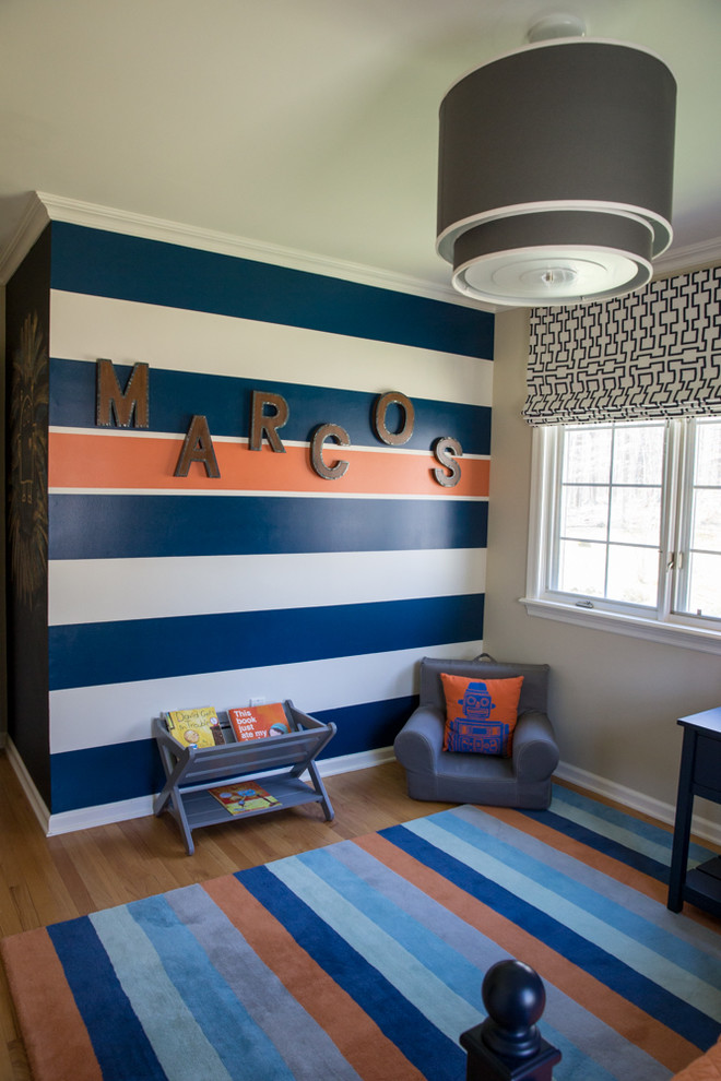 This is an example of a mid-sized transitional kids' bedroom for kids 4-10 years old and boys in New York with beige walls and light hardwood floors.