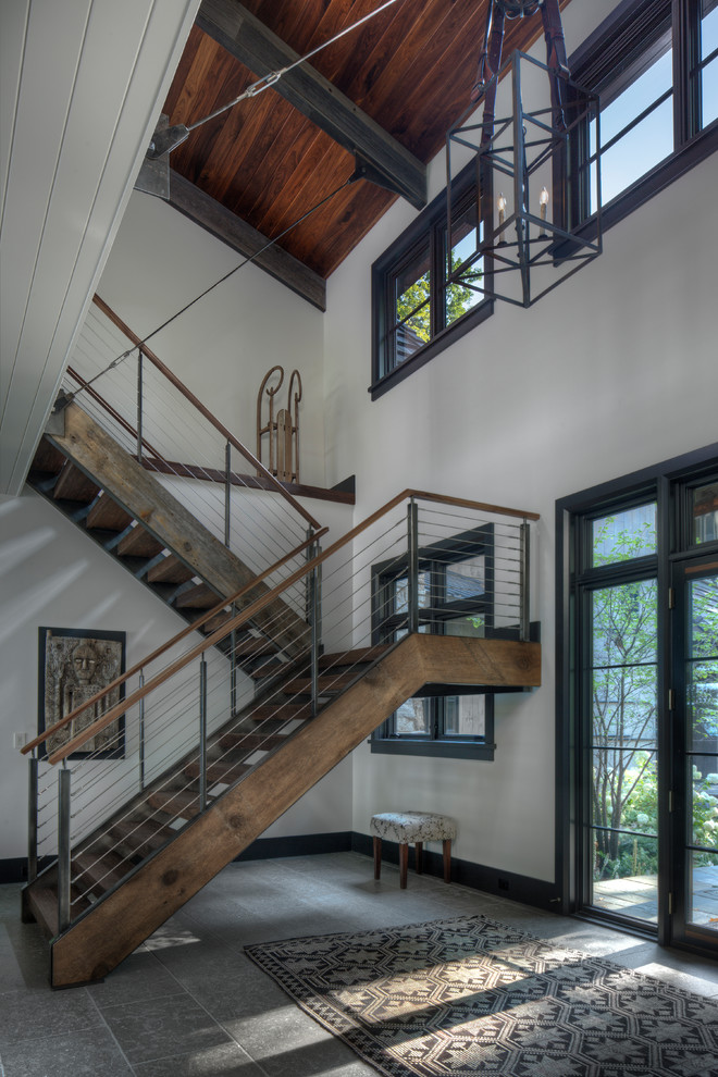 Large country wood u-shaped staircase in Other with open risers and metal railing.
