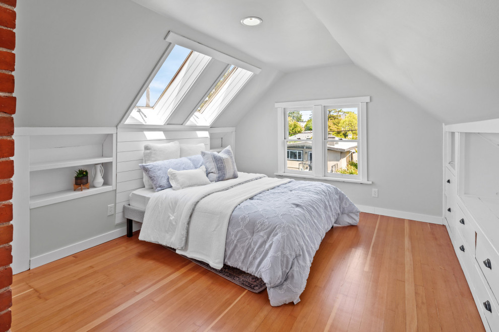 Esempio di una camera da letto stile loft stile americano con pavimento in legno massello medio e pavimento marrone