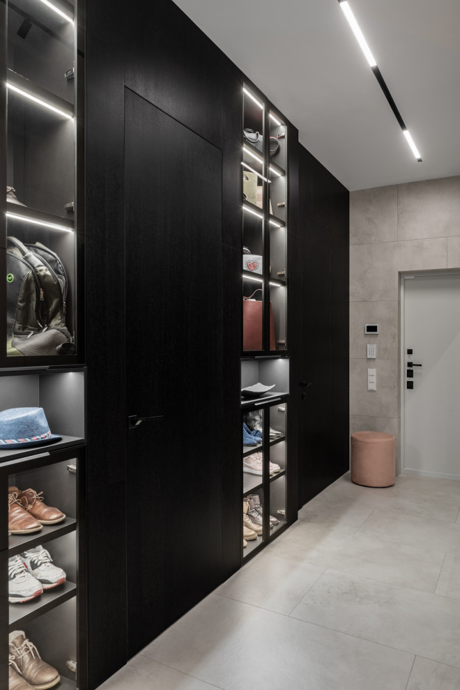На фото: узкая прихожая среднего размера со шкафом для обуви в современном стиле с полом из керамогранита, одностворчатой входной дверью, серым полом, панелями на стенах и серыми стенами