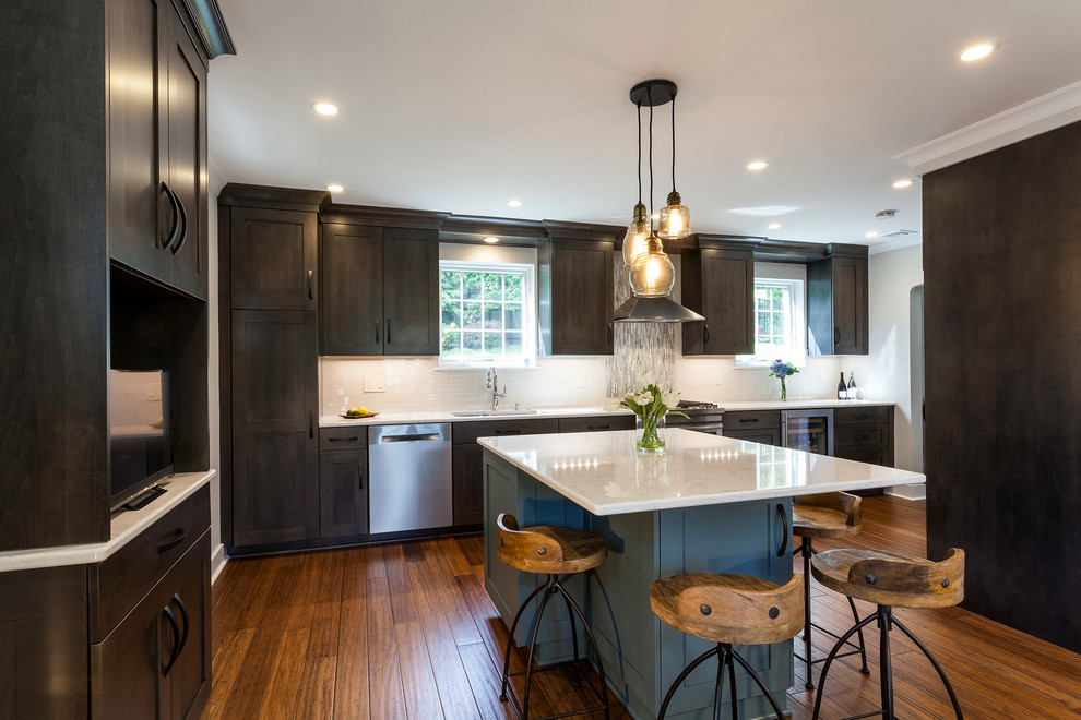 Eat-in kitchen - mid-sized transitional bamboo floor eat-in kitchen idea with an undermount sink, shaker cabinets, dark wood cabinets, quartz countertops, gray backsplash, ceramic backsplash, stainless steel appliances and an island