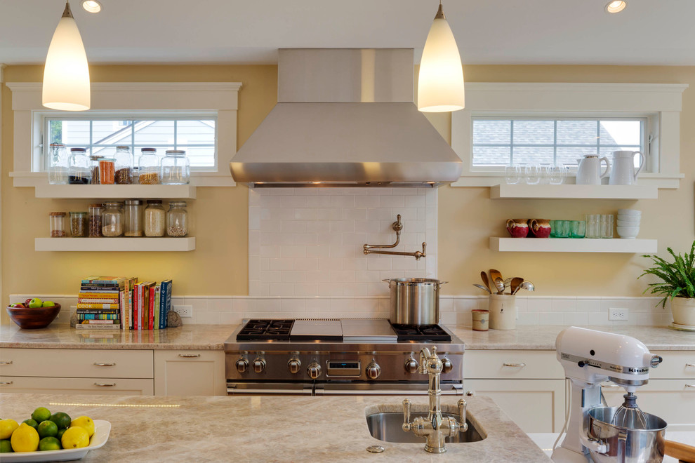 Kitchen - large transitional l-shaped light wood floor kitchen idea in Boston with a farmhouse sink, recessed-panel cabinets, white cabinets, quartz countertops, white backsplash, subway tile backsplash, stainless steel appliances and an island