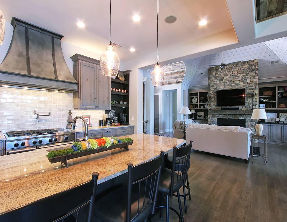 Photo of a large transitional open plan kitchen in Charlotte with a double-bowl sink, flat-panel cabinets, grey cabinets, granite benchtops, stainless steel appliances, light hardwood floors and with island.