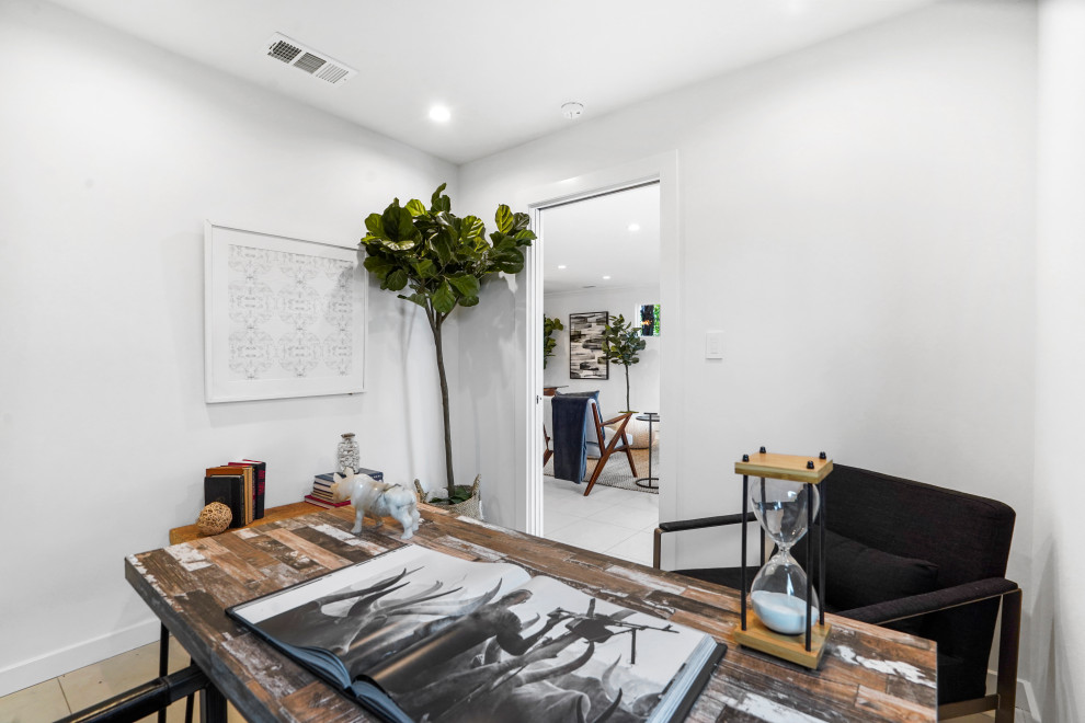 Idee per un piccolo studio minimal con pareti bianche, pavimento in gres porcellanato, scrivania autoportante e pavimento beige
