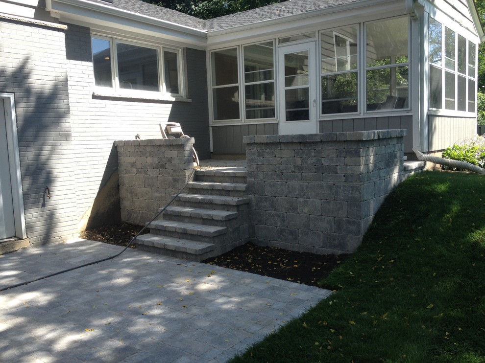 This is an example of a mid-sized traditional backyard patio in Chicago with concrete pavers.