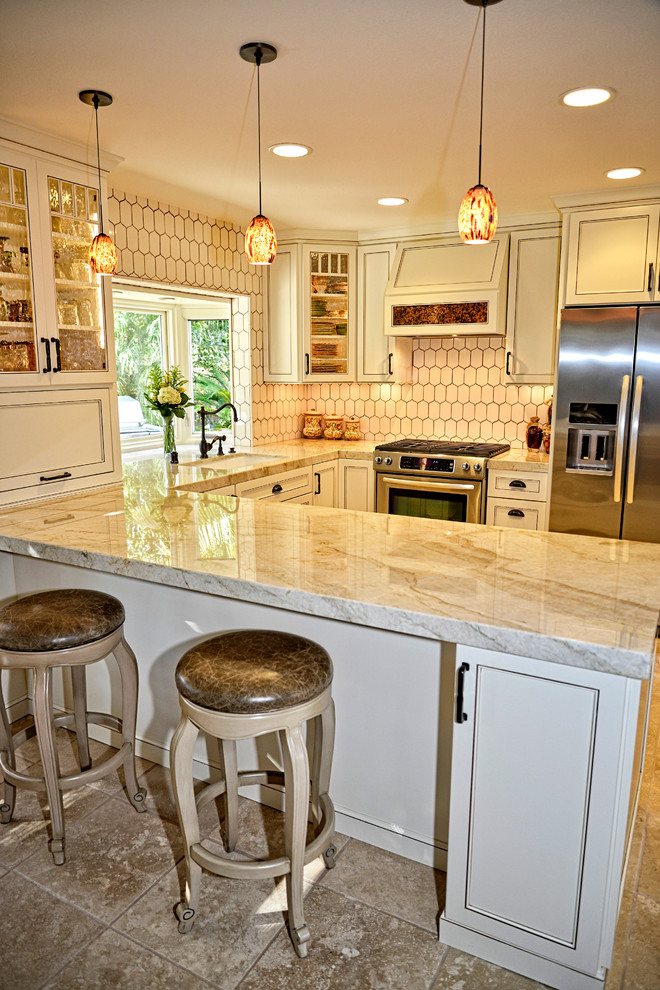 Mid-sized country u-shaped eat-in kitchen in San Diego with white cabinets, white splashback, stainless steel appliances, travertine floors, a peninsula, an undermount sink, recessed-panel cabinets, marble benchtops, porcelain splashback and beige floor.