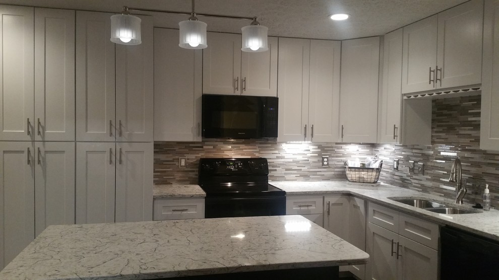 Example of a mid-sized transitional l-shaped porcelain tile kitchen design in Raleigh with an undermount sink, shaker cabinets, white cabinets, quartz countertops, metallic backsplash, mosaic tile backsplash, black appliances and an island