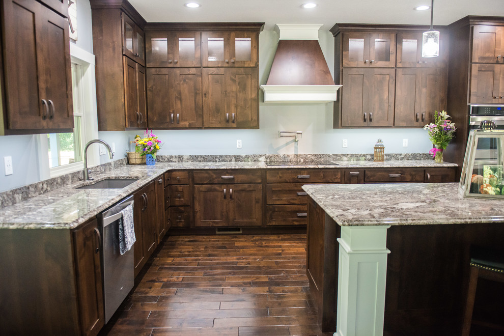 Example of a transitional l-shaped open concept kitchen design with an undermount sink, shaker cabinets, dark wood cabinets, granite countertops, stainless steel appliances, an island and multicolored countertops