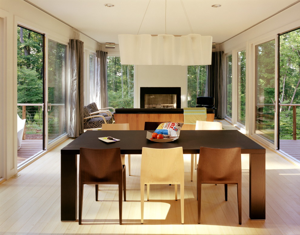 Design ideas for a modern dining room in Raleigh with a standard fireplace.