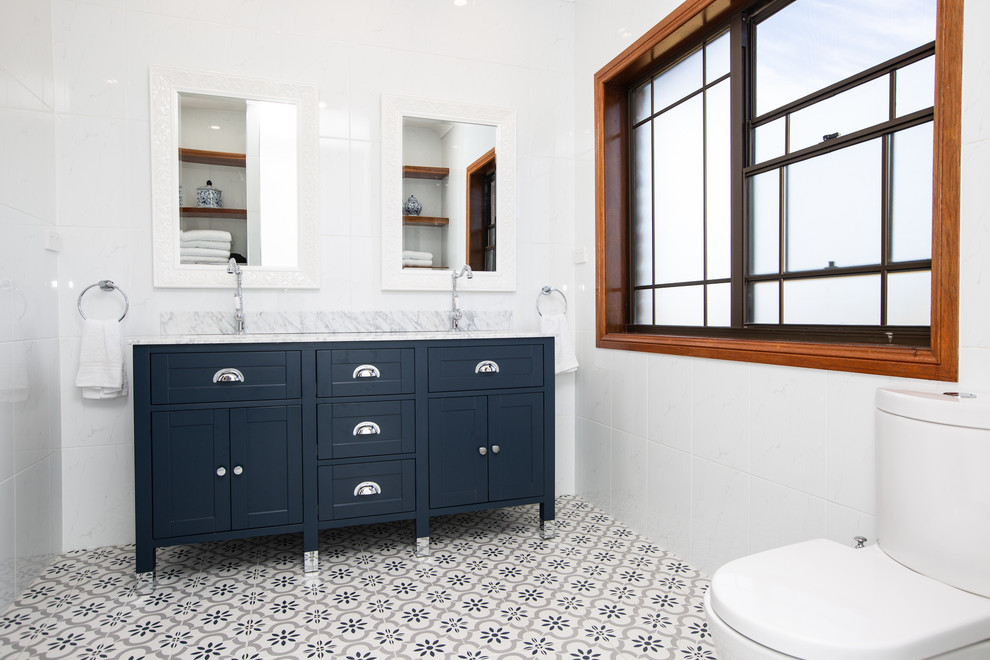 Inspiration for a large contemporary master bathroom in Sydney with furniture-like cabinets, blue cabinets, an open shower, a one-piece toilet, white tile, ceramic tile, white walls, ceramic floors, an undermount sink, granite benchtops, blue floor, an open shower and blue benchtops.