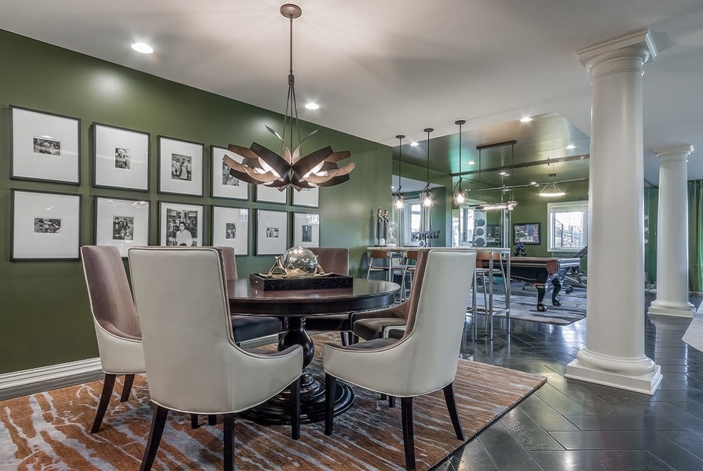Expansive modern dining room in Omaha with green walls, travertine floors, a standard fireplace and a brick fireplace surround.