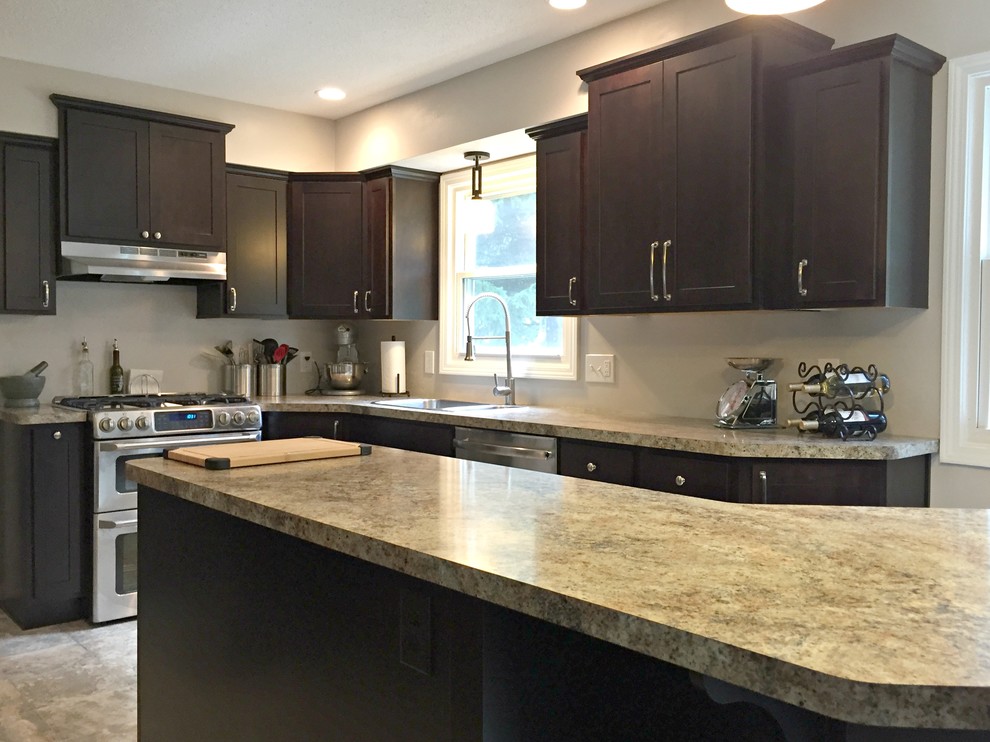 Open concept kitchen - mid-sized transitional l-shaped limestone floor open concept kitchen idea with a drop-in sink, shaker cabinets, dark wood cabinets, granite countertops, stainless steel appliances and an island