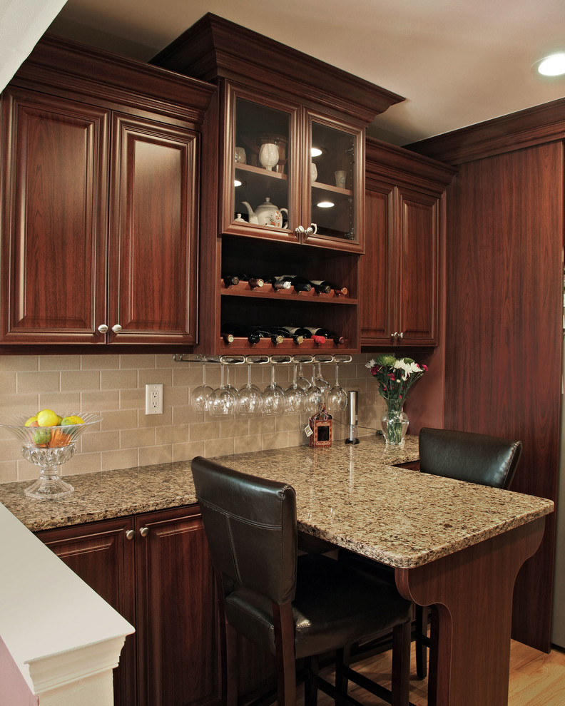 This is an example of a mid-sized tropical galley eat-in kitchen in Philadelphia with a single-bowl sink, raised-panel cabinets, dark wood cabinets, quartzite benchtops, beige splashback, subway tile splashback, stainless steel appliances, light hardwood floors and with island.