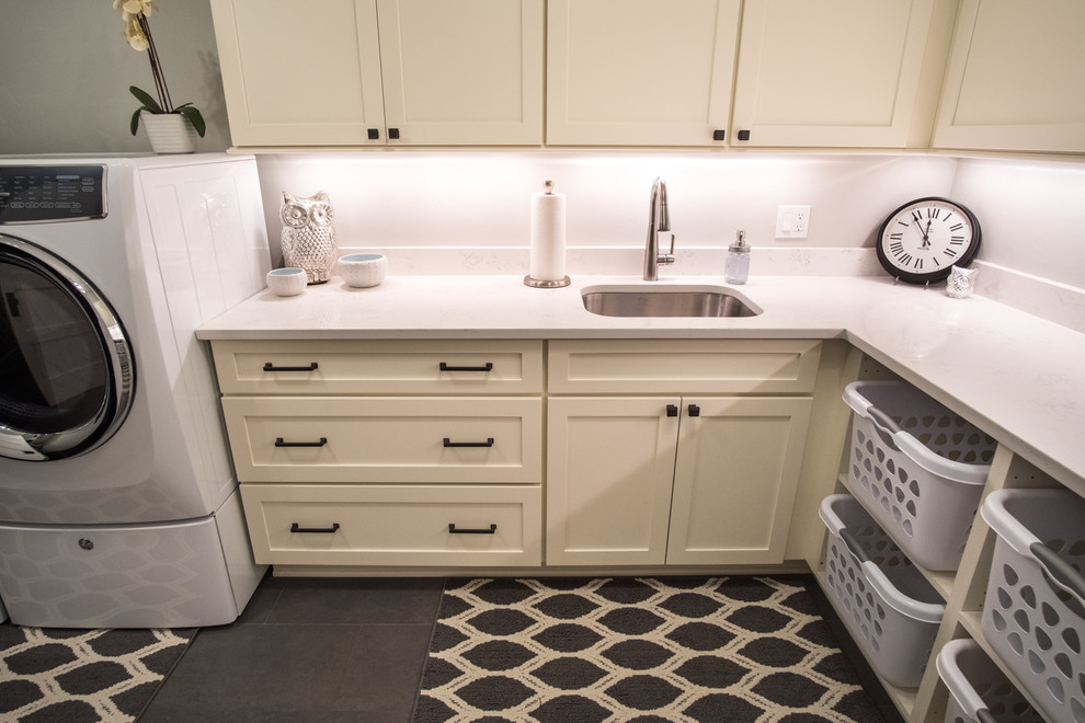 Large transitional l-shaped dedicated laundry room in Portland with an undermount sink, shaker cabinets, white cabinets, quartz benchtops, grey walls, slate floors, a side-by-side washer and dryer, grey floor and white benchtop.