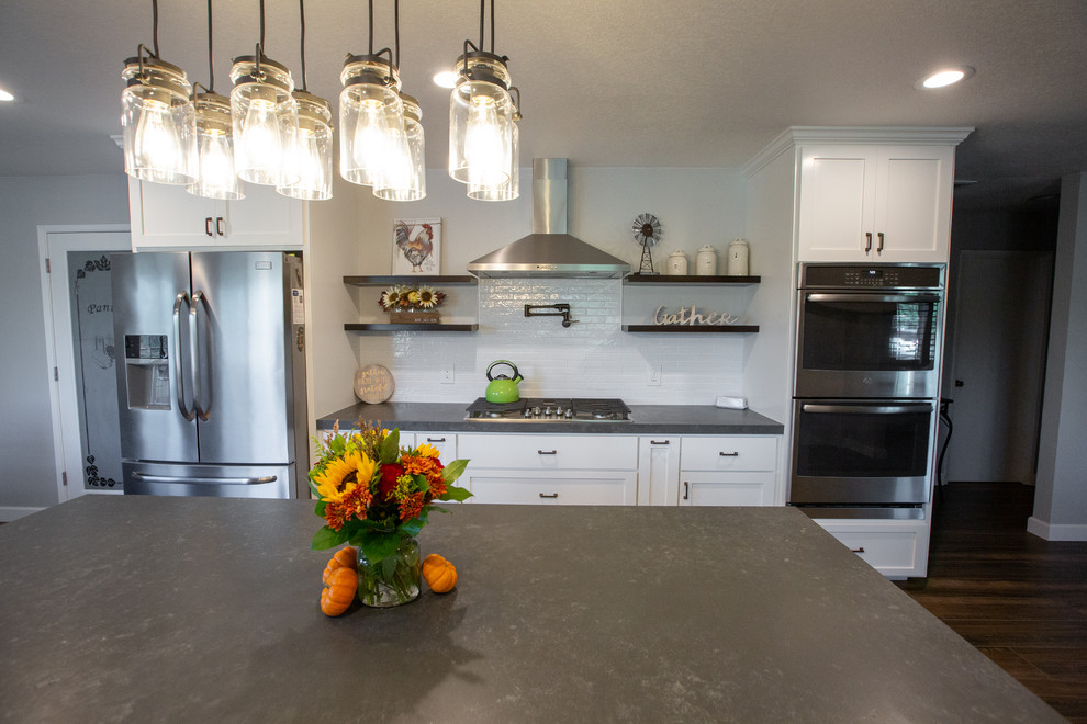 Contemporary kitchen in Sacramento with a farmhouse sink, white cabinets, quartz benchtops, white splashback, ceramic splashback, stainless steel appliances, porcelain floors, with island, multi-coloured floor and grey benchtop.