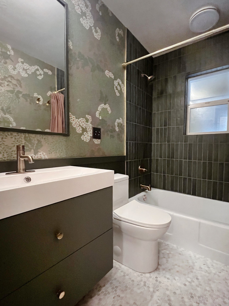 This is an example of a small midcentury kids bathroom in Portland with flat-panel cabinets, green cabinets, an alcove tub, a shower/bathtub combo, a one-piece toilet, green tile, ceramic tile, green walls, marble floors, an integrated sink, white floor, a shower curtain, a single vanity, a floating vanity and wallpaper.
