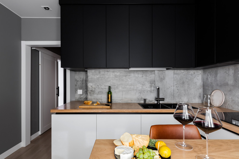 Design ideas for a small contemporary l-shaped eat-in kitchen in Saint Petersburg with an undermount sink, flat-panel cabinets, black cabinets, wood benchtops, grey splashback, porcelain splashback, black appliances, laminate floors, no island, beige floor and beige benchtop.