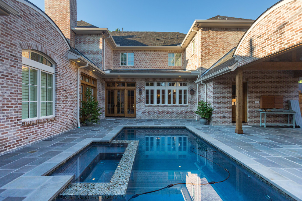 Mid-sized contemporary custom-shaped lap pool in Houston with a hot tub and natural stone pavers.