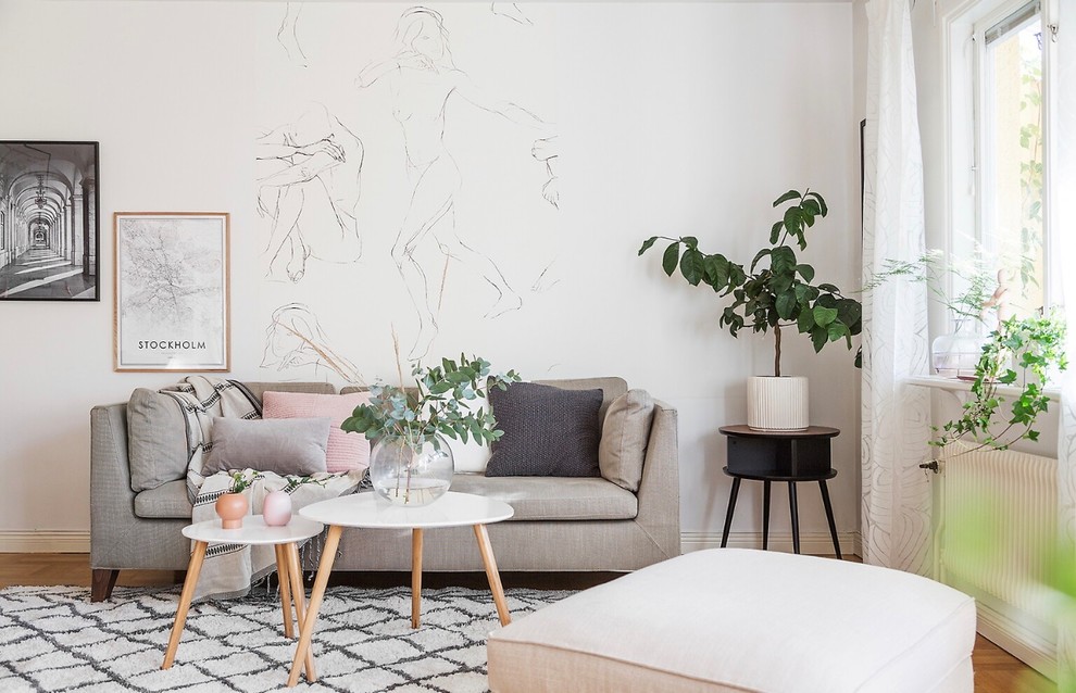 Scandinavian open concept living room in Stockholm with white walls and medium hardwood floors.