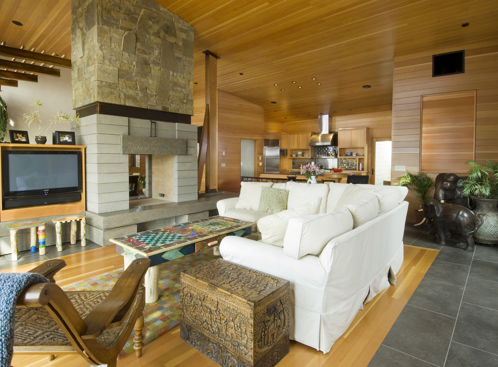 Design ideas for a contemporary living room in Seattle with a stone fireplace surround and a two-sided fireplace.