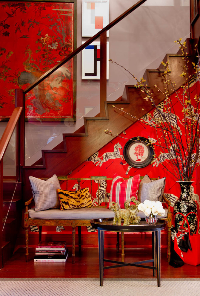 This is an example of an eclectic entryway in New York with red walls.