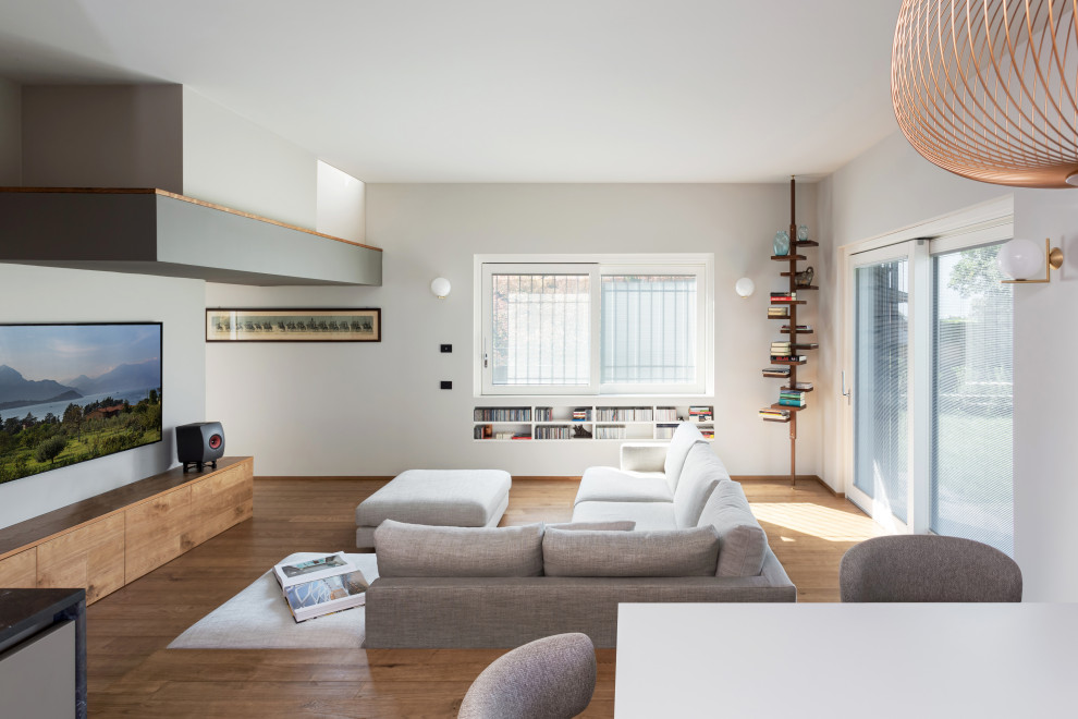 Geräumiges, Offenes Modernes Wohnzimmer mit weißer Wandfarbe, braunem Holzboden, TV-Wand, beigem Boden und eingelassener Decke in Sonstige