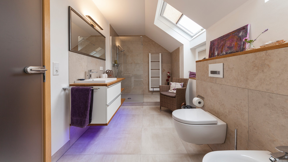 This is an example of a mid-sized contemporary 3/4 bathroom in Other with recessed-panel cabinets, white cabinets, an open shower, a two-piece toilet, beige tile, white walls, a drop-in sink, wood benchtops, beige floor, an open shower and brown benchtops.