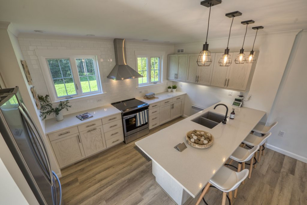 Design ideas for a mid-sized beach style l-shaped eat-in kitchen in Other with an undermount sink, shaker cabinets, grey cabinets, quartzite benchtops, white splashback, subway tile splashback, stainless steel appliances, laminate floors, with island, beige floor and white benchtop.