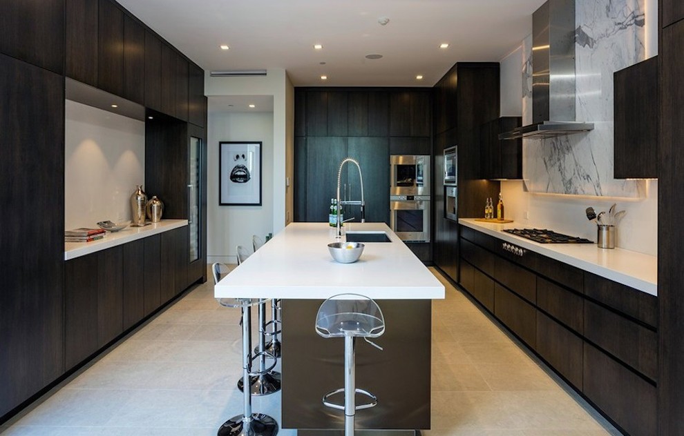 Photo of a mid-sized modern u-shaped kitchen in Los Angeles with an undermount sink, flat-panel cabinets, dark wood cabinets, quartz benchtops, white splashback, marble splashback, stainless steel appliances, limestone floors and with island.