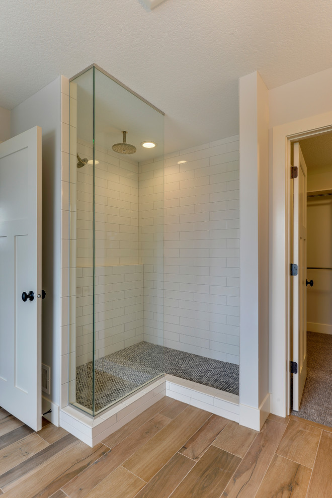 This is an example of a mid-sized country master bathroom in Minneapolis with open cabinets, blue cabinets, a claw-foot tub, an open shower, a one-piece toilet, grey walls, porcelain floors, a trough sink, marble benchtops, brown floor and an open shower.