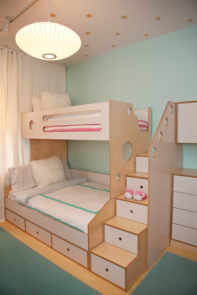 Design ideas for a contemporary gender-neutral kids' bedroom for kids 4-10 years old in New York with blue walls and light hardwood floors.