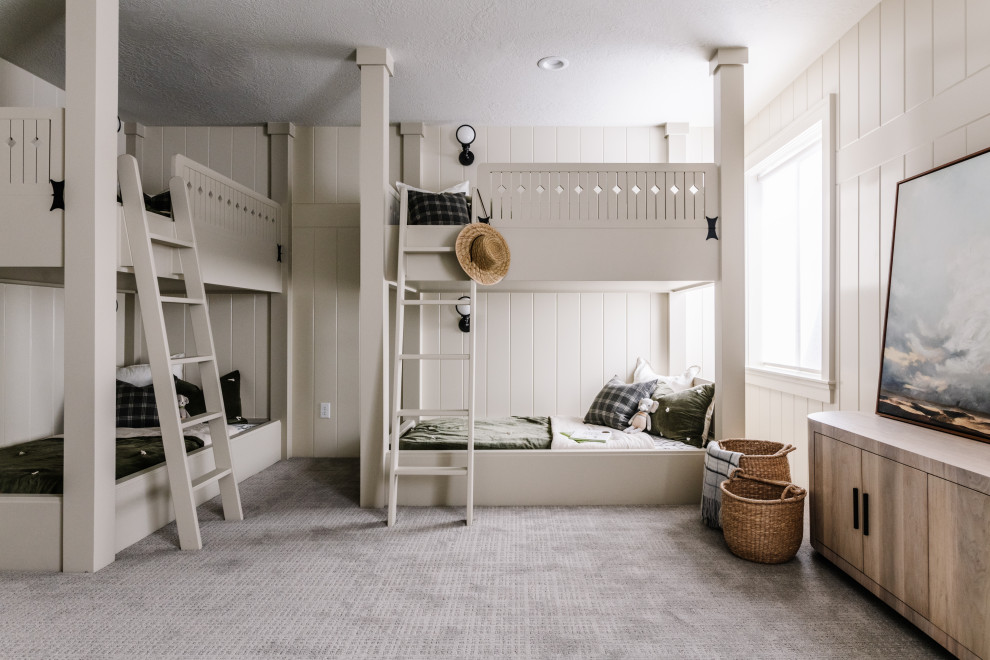 Idéer för ett klassiskt könsneutralt barnrum kombinerat med sovrum, med vita väggar, heltäckningsmatta och grått golv