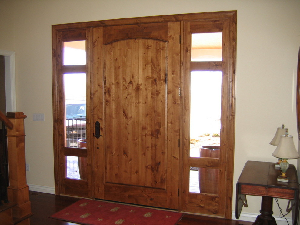 Example of a mid-sized mountain style dark wood floor and brown floor front door design in Denver with beige walls and a dark wood front door
