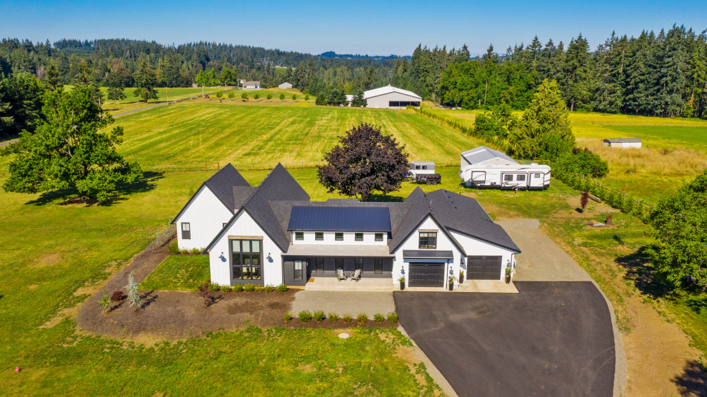 Example of a huge farmhouse white two-story vinyl and board and batten exterior home design in Portland with a shingle roof and a black roof