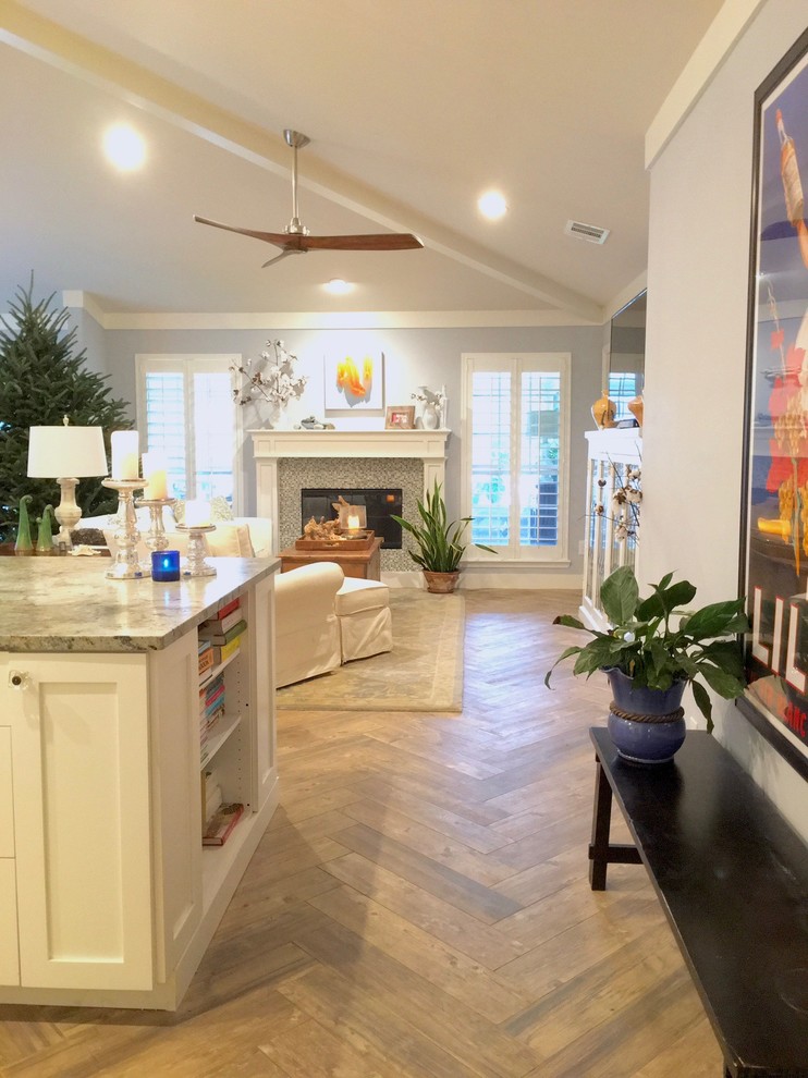 This is an example of a mid-sized beach style open concept living room in Jacksonville with blue walls, porcelain floors, a standard fireplace, a wood fireplace surround, no tv and brown floor.