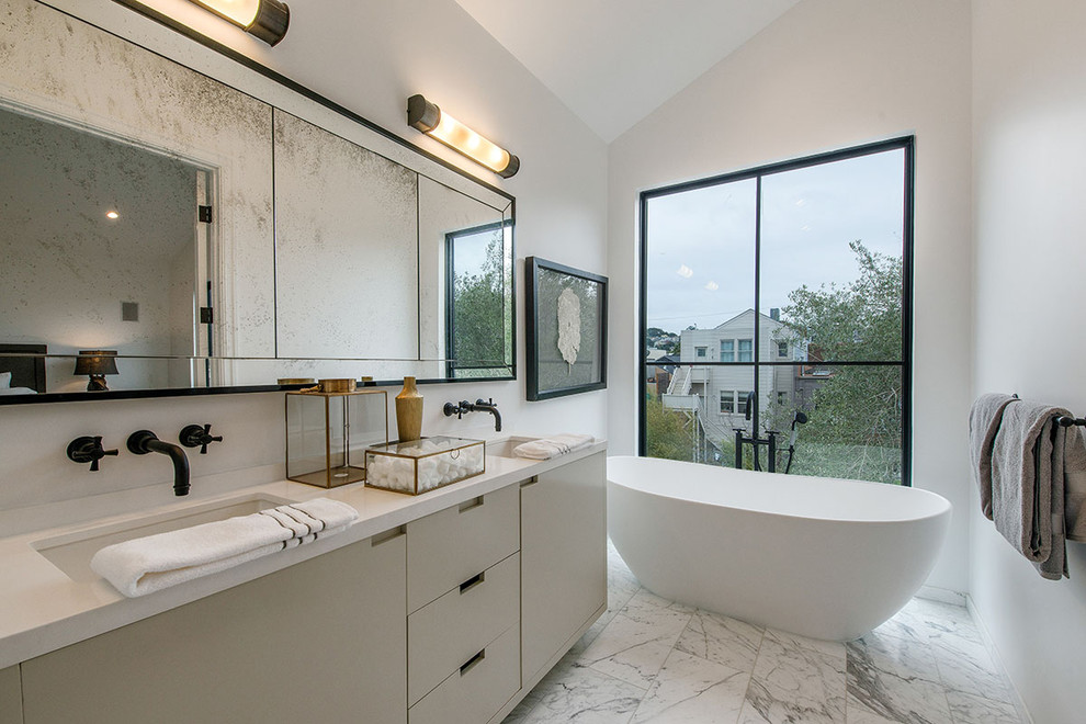 This is an example of a large contemporary master bathroom in San Francisco with flat-panel cabinets, beige cabinets, a freestanding tub, gray tile, porcelain tile, white walls, porcelain floors, an undermount sink and engineered quartz benchtops.