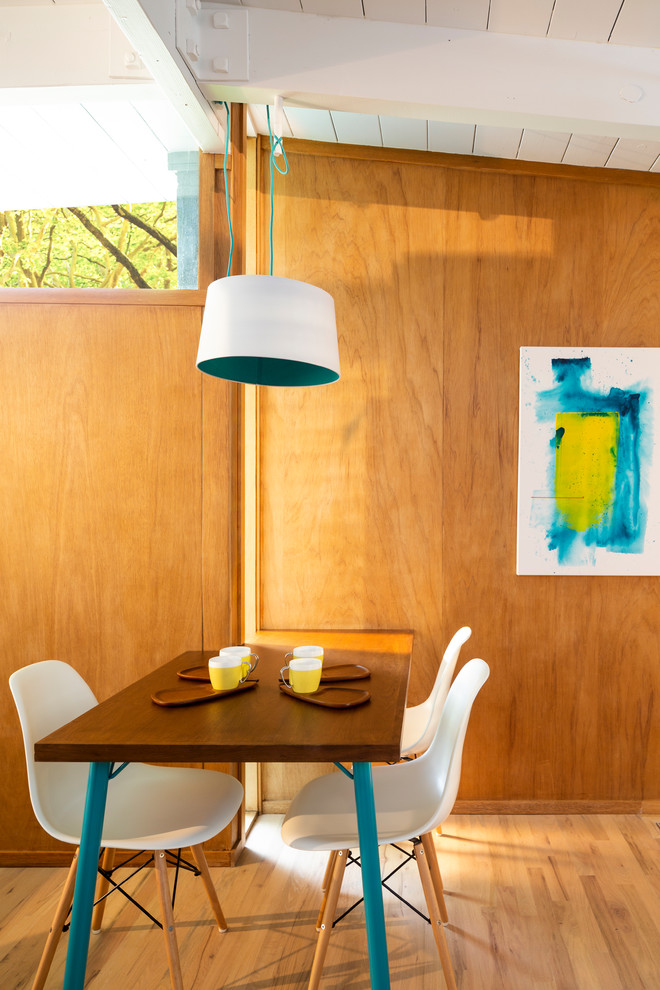 Inspiration for a midcentury dining room in Denver with brown walls and light hardwood floors.