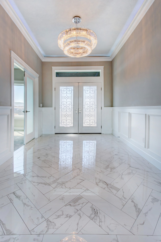 Example of a mid-sized transitional marble floor and white floor entry hall design in Seattle with gray walls and a white front door