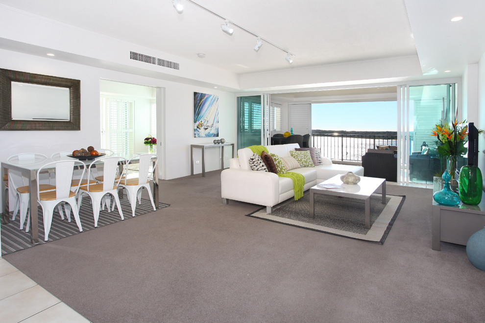 Inspiration for a mid-sized beach style open concept living room in Gold Coast - Tweed with white walls, carpet and a freestanding tv.