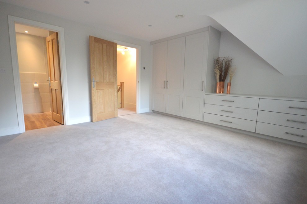 Large traditional master bedroom in Surrey with grey walls, carpet and no fireplace.