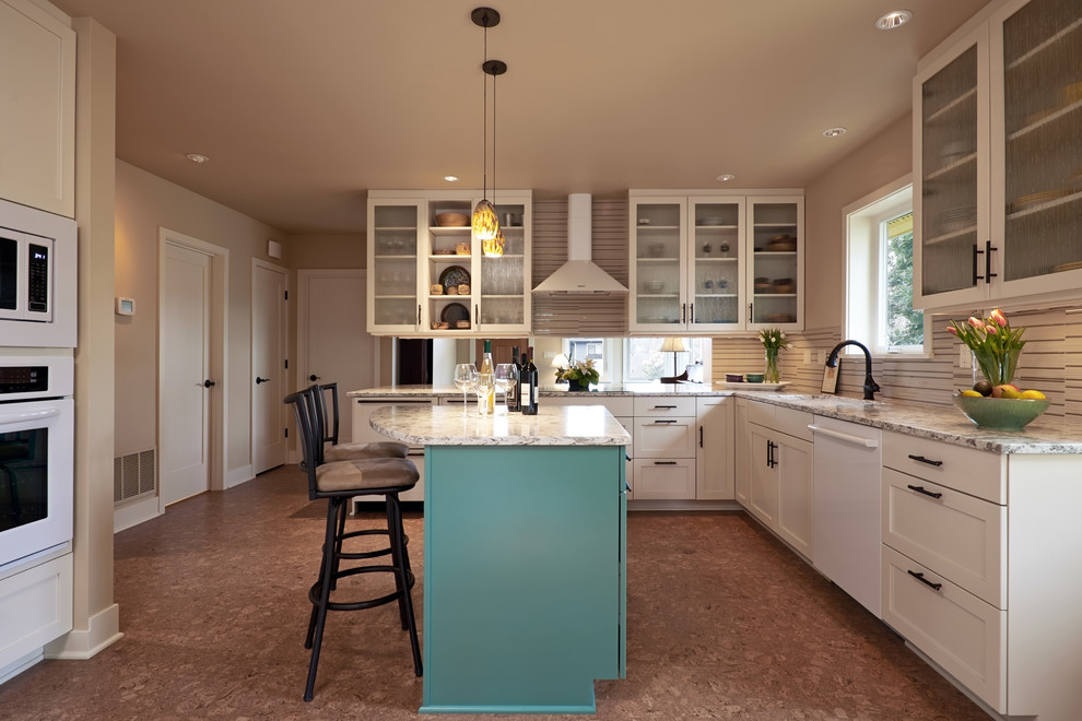 Inspiration for a mid-sized arts and crafts l-shaped eat-in kitchen in Seattle with shaker cabinets, white cabinets, white appliances, cork floors, with island, quartzite benchtops, beige splashback, glass tile splashback, an undermount sink, brown floor and multi-coloured benchtop.