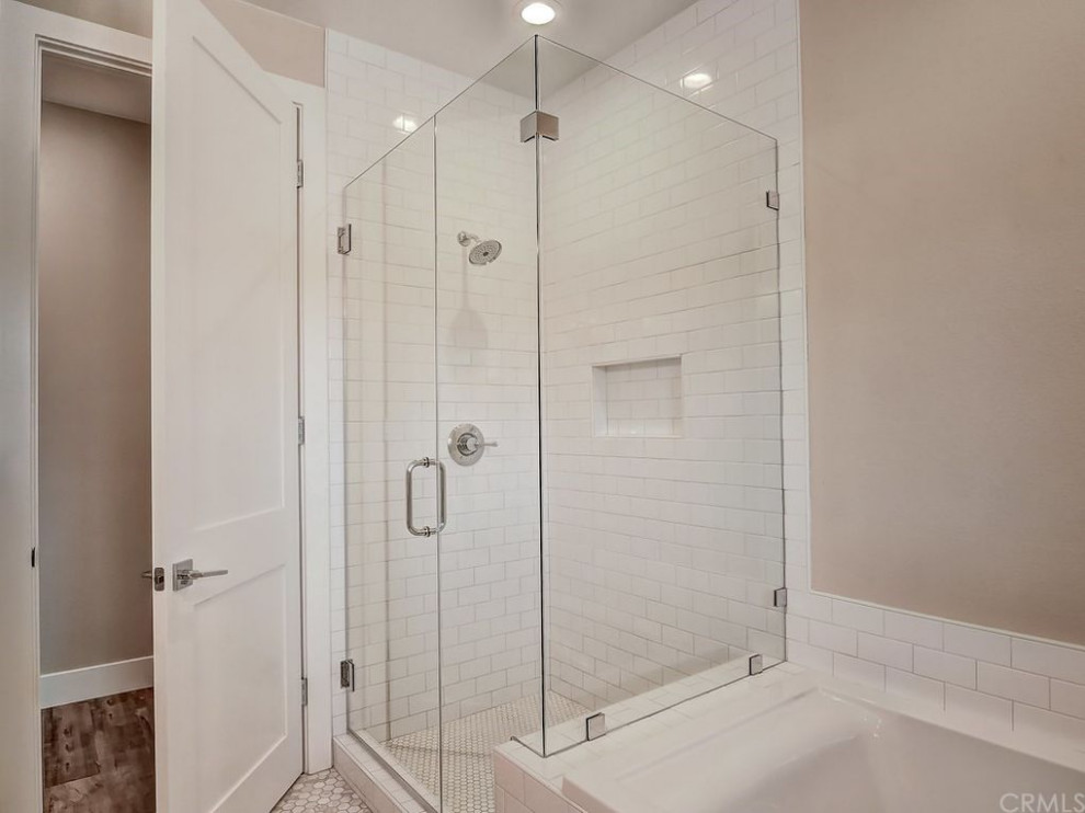 Large country kids bathroom in Orange County with shaker cabinets, white cabinets, a corner shower, white tile, ceramic tile, beige walls, cement tiles, white floor, a hinged shower door and a built-in vanity.
