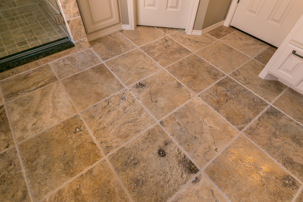 Large transitional master beige tile and stone tile travertine floor freestanding bathtub photo in Austin with raised-panel cabinets, gray cabinets, a two-piece toilet, gray walls, an undermount sink and granite countertops