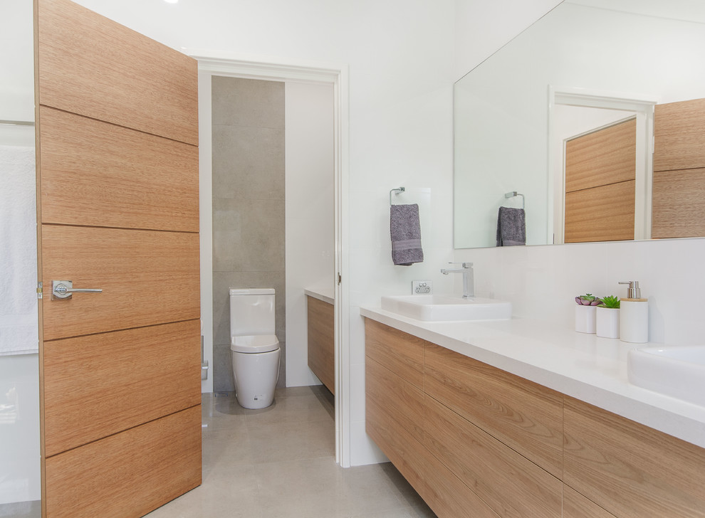 This is an example of a large modern 3/4 bathroom in Perth with flat-panel cabinets, medium wood cabinets, an open shower, yellow tile, ceramic tile, ceramic floors, a vessel sink, engineered quartz benchtops, green floor, an open shower and white benchtops.