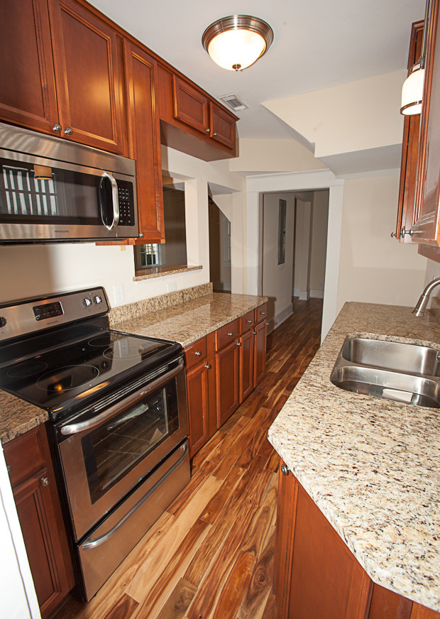 Inspiration for a transitional medium tone wood floor kitchen remodel in Charleston with an undermount sink, medium tone wood cabinets, granite countertops and stainless steel appliances