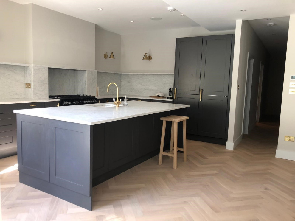 Medium sized traditional galley open plan kitchen in London with a built-in sink, shaker cabinets, dark wood cabinets, marble worktops, grey splashback, marble splashback, integrated appliances, an island and grey worktops.