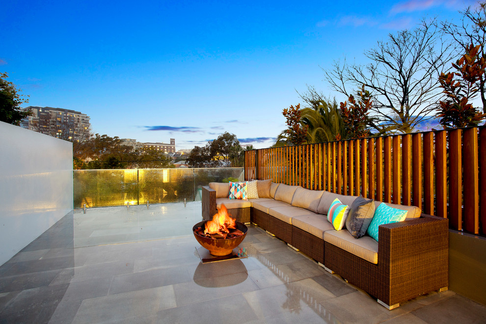 Modern backyard patio in Sydney with a fire feature.
