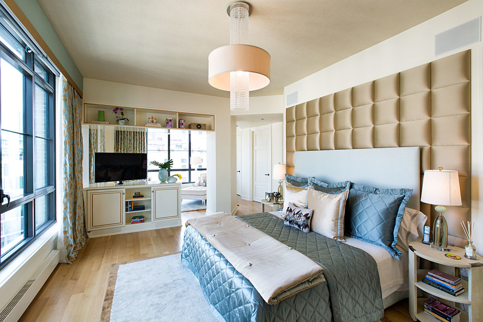 Contemporary bedroom in New York with beige walls and medium hardwood floors.